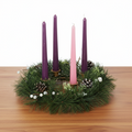 Advent candles with pine wreath on wooden table with white background