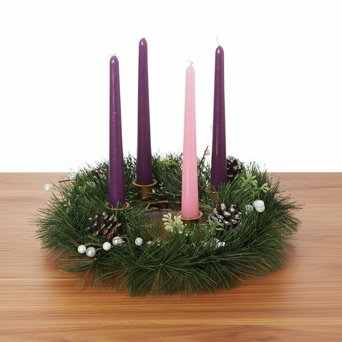 Advent candles with pine wreath on wooden table with white background