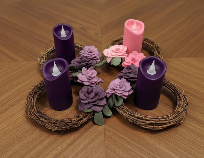 Advent candles with grapevine wreaths on wooden table