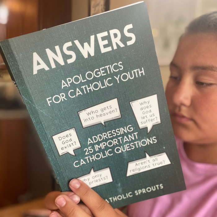 Book titled 'Answers Apologetics for Catholic Youth' held by a person.