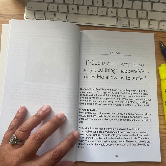 Open book with text on a wooden surface next to a keyboard