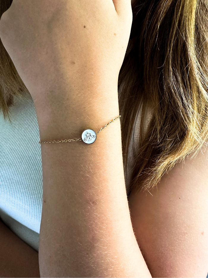 Gold chain with circle white middle with gold border on hand
