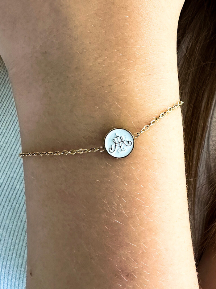 Gold chain with circle white middle with gold border on hand