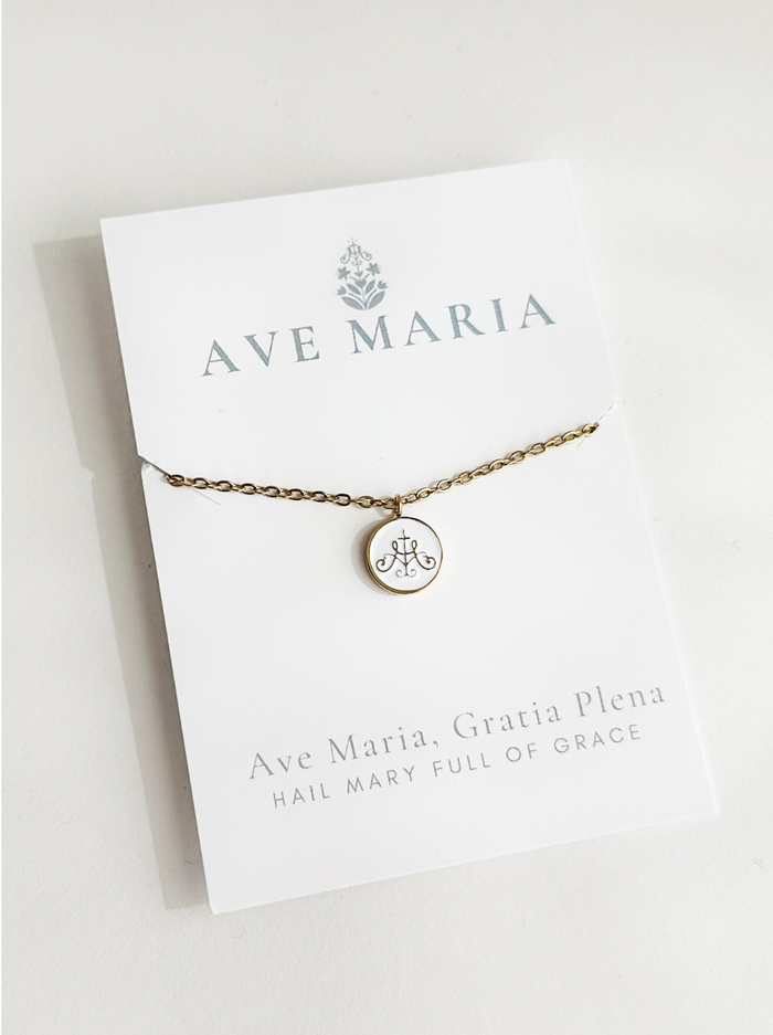 Ava Maria symbol on white background with gold border attached to golden chain