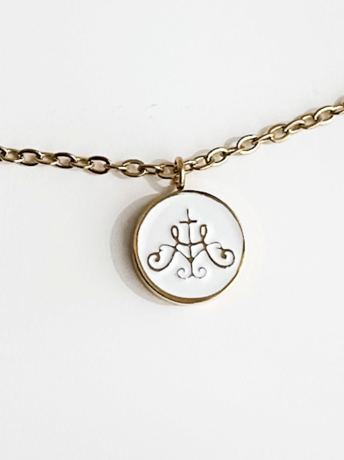 Ava Maria symbol on white background with gold border attached to golden chain