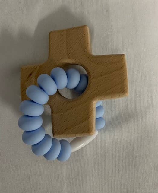 Wooden cross-shaped teether with blue silicone beads on a beige background