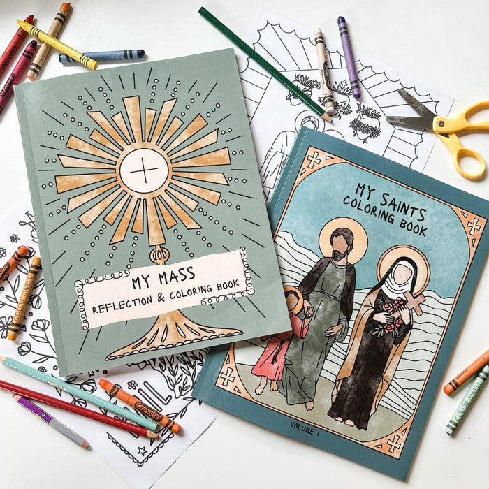 Two coloring books titled 'My Mass' and 'My Saints' on a table with coloring supplies.