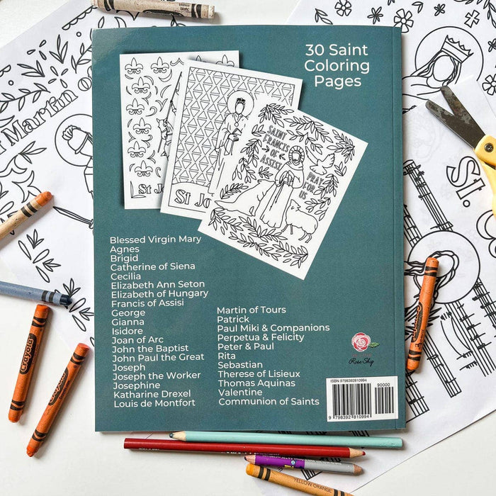 Coloring book with 30 Saint Coloring Pages on a table with coloring supplies.