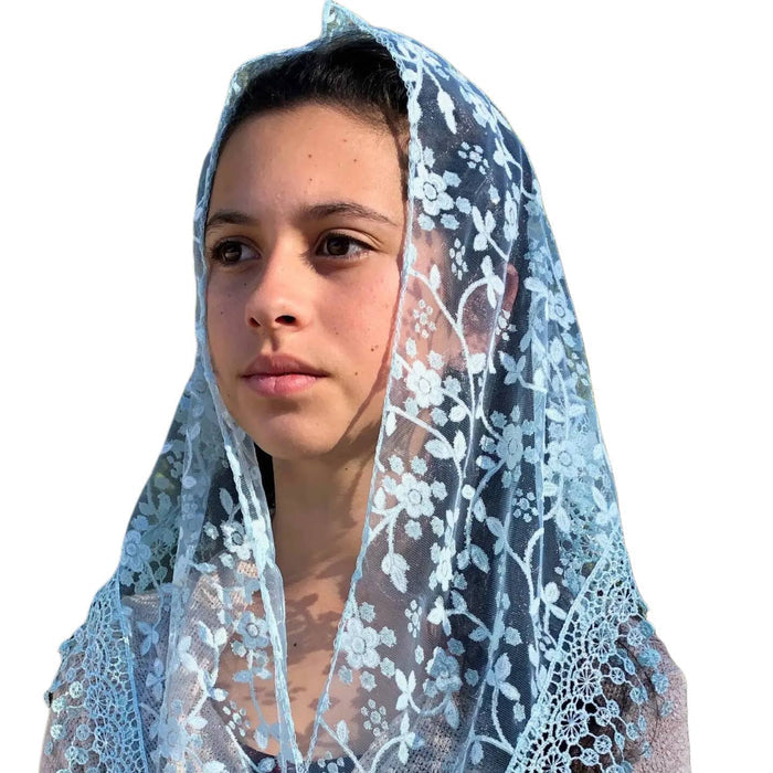 Person wearing a light blue lace veil on a white background
