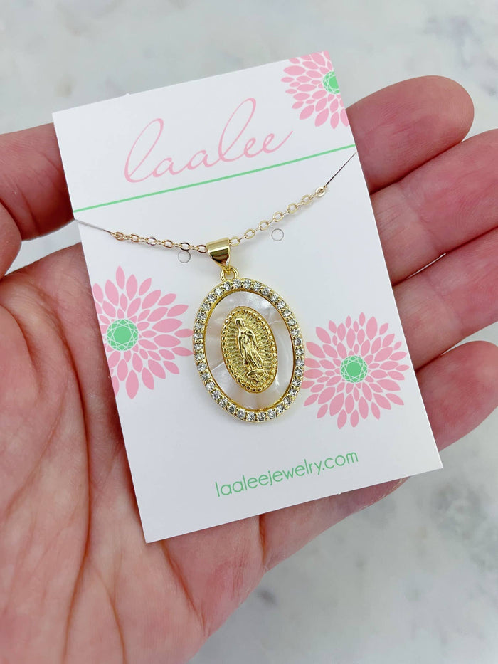 Gold necklace with a pendant on a 'Laalee' branded card held by a hand.