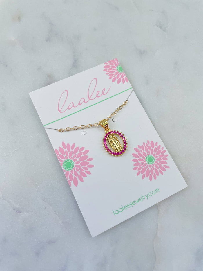 Gold necklace with a pink pendant on a 'laalee' branded card with floral designs on a marble background.
