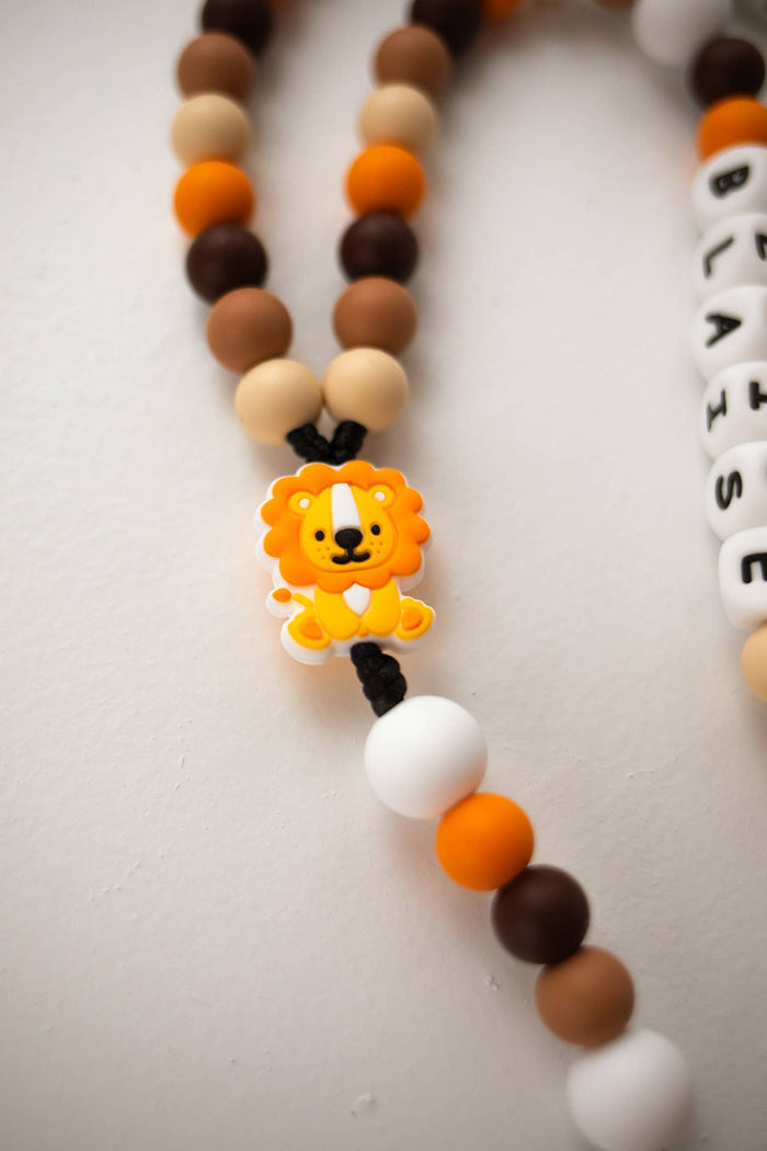 Rosary with lion charm and colorful beads on a light background