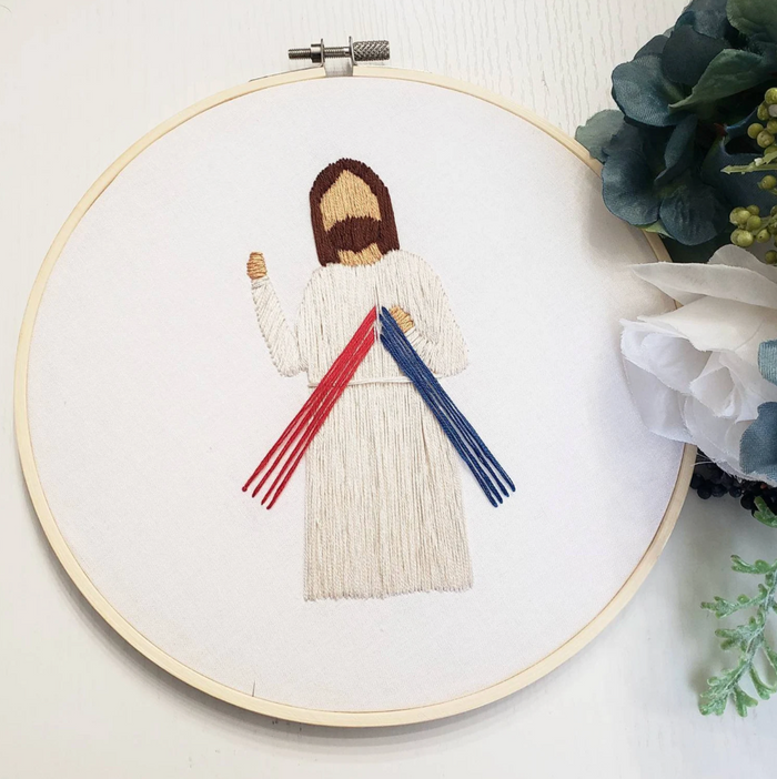 Embroidery of Jesus in an embroidery hoop on a white background.