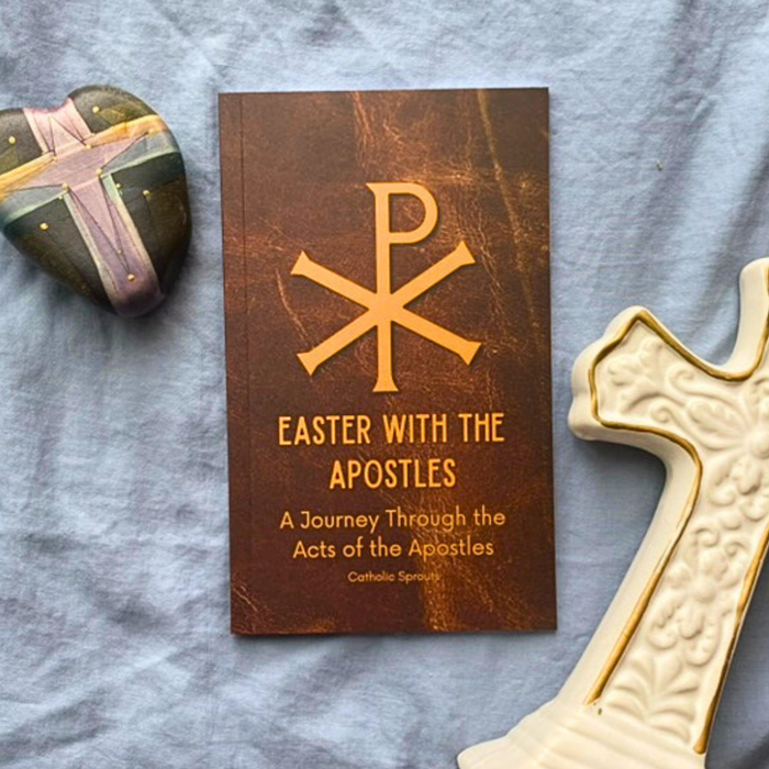 Book titled 'Easter with the Apostles' on a textured surface with a cross and heart-shaped object.