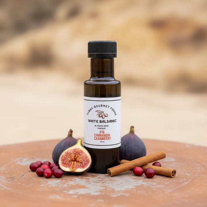 Fig Cinnamon Cranberry White Balsamic Vinegar bottle with figs, cranberries and cinnamon on terracotta surface