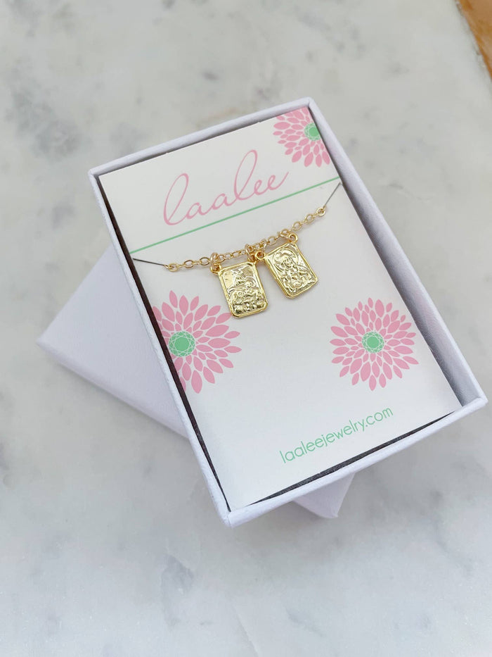 Gold necklace with two pendants on a 'Laalee' branded card with floral designs.