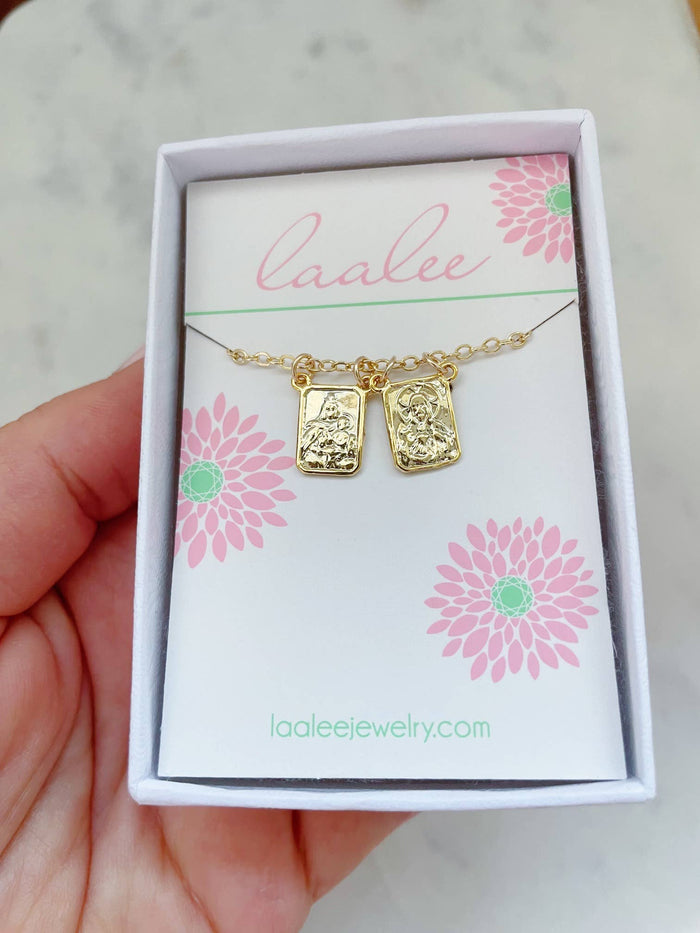 Gold necklace with pendant on a 'Laalee' branded card held by a hand.