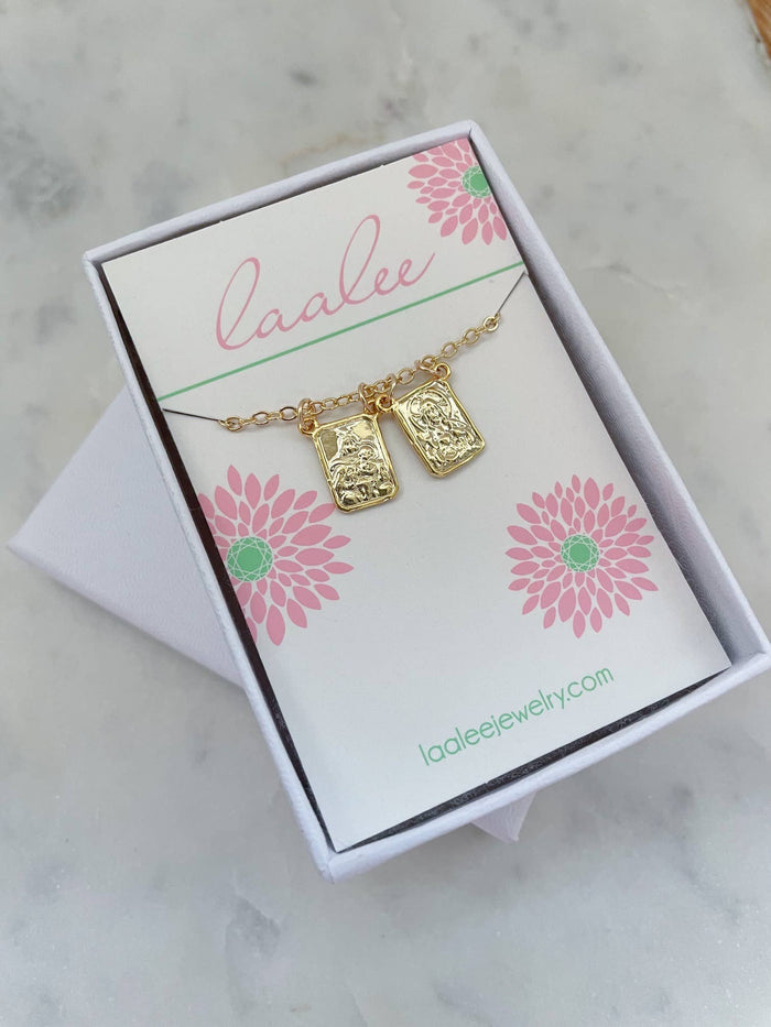 Gold necklace with pendant on a 'Laalee' branded card with floral designs.