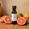 Grapefruit White Balsamic Vinegar bottle with fresh grapefruit on terracotta surface