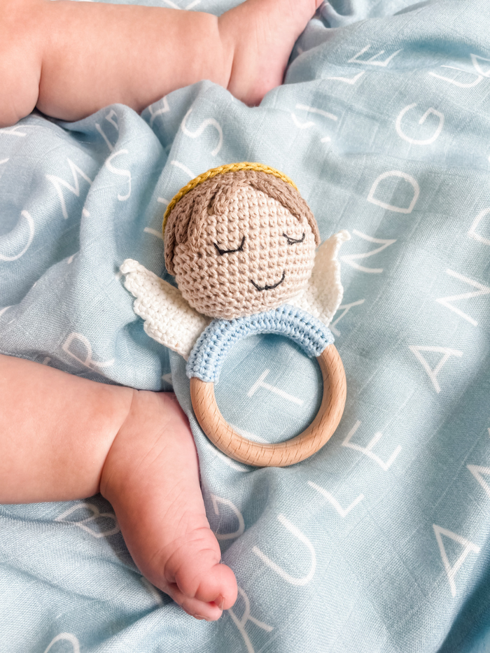 Crocheted angel teething ring with a light blue blanket underneath