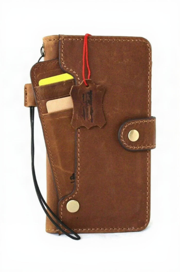 A brown leather phone wallet case with multiple card slots, a black wrist strap, and brass snap buttons, shown on a white background with a hanging leather tag.