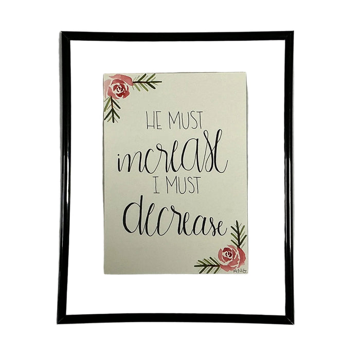 Framed print with motivational quote 'He must increase, I must decrease' and floral elements on a beige background.