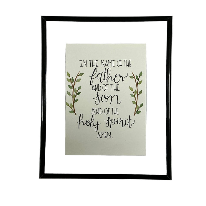Framed print with religious text and leaves on a white fabric background