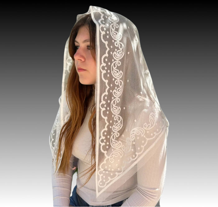 Woman wearing a white lace veil against a gradient background