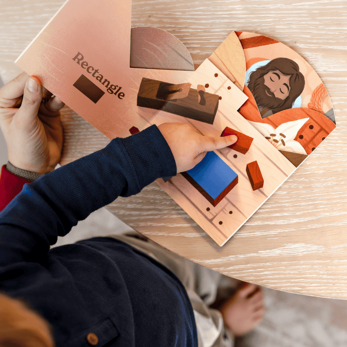 Person interacting with a wooden shape sorting toy on a wooden surface