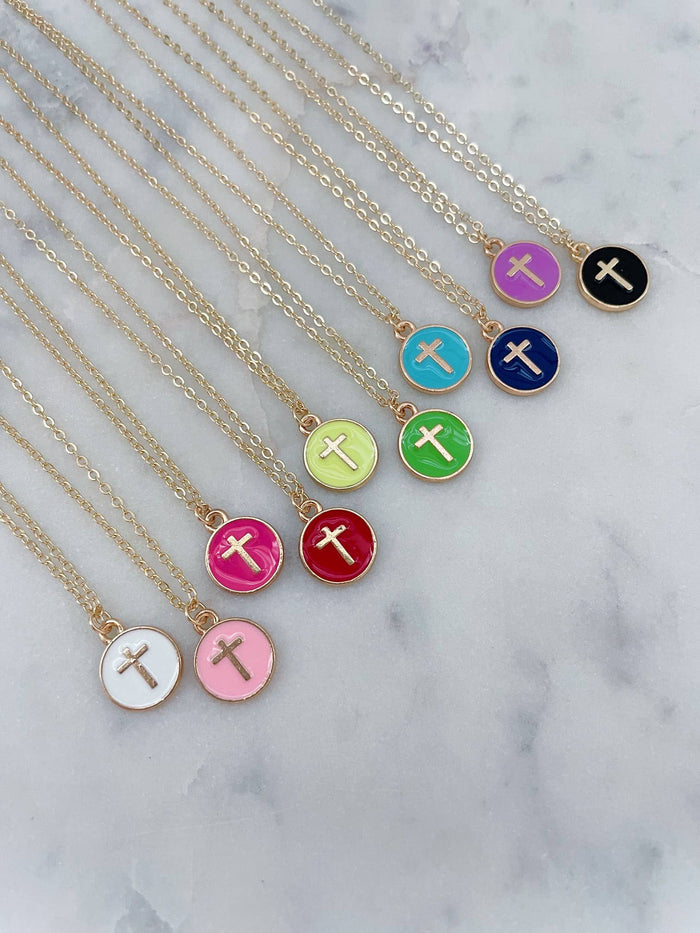 Necklaces with colorful circular pendants featuring crosses on a marble surface