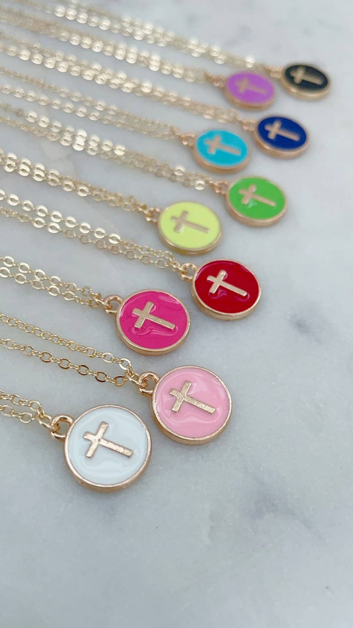 Necklaces with colorful circular pendants featuring crosses on a marble surface