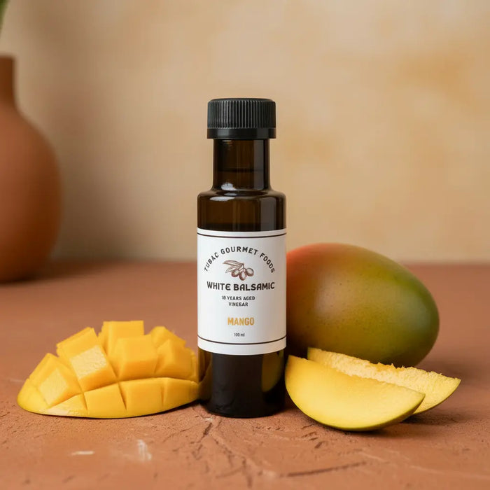 Mango White Balsamic Vinegar bottle with fresh mango on terracotta surface