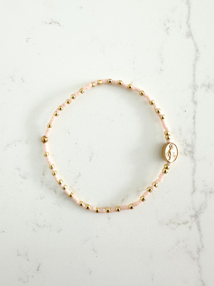 Gold beaded bracelet on a marble surface