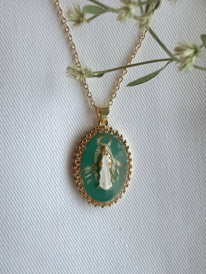 Gold necklace with a pendant featuring a religious icon on a white background