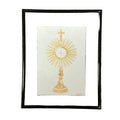 Framed artwork of a gold monstrance on a white background