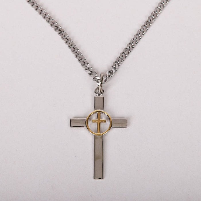 Cross-shaped pendant with gold center on a chain against a light gray background