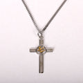 Silver cross necklace with a central emblem on a white background