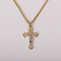Gold cross necklace with Jesus pendant on a light gray background