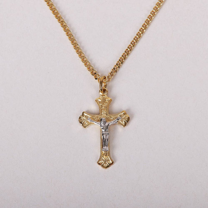 Gold cross necklace with Jesus pendant on a light gray background