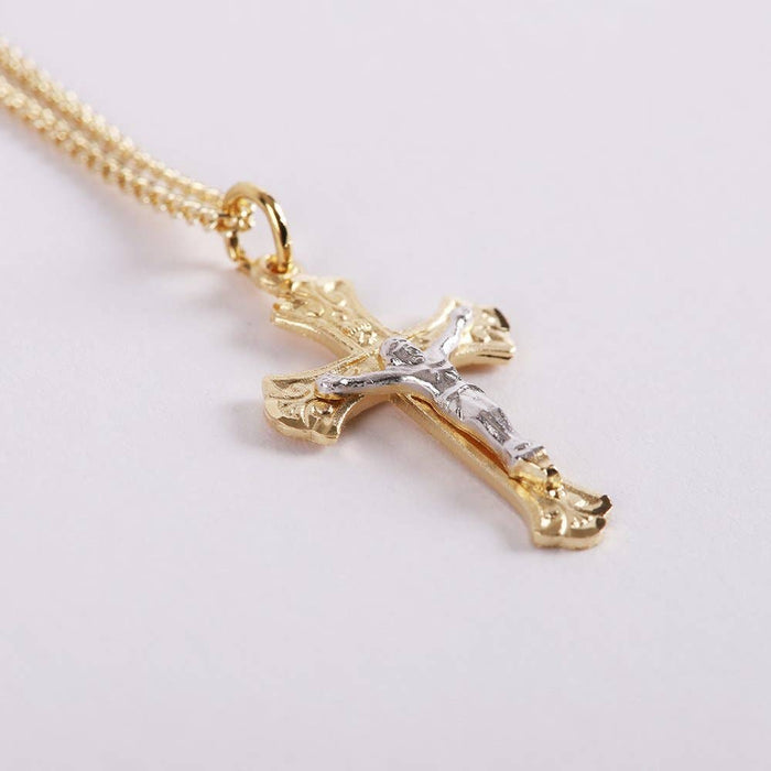 Gold cross pendant on a light gray background