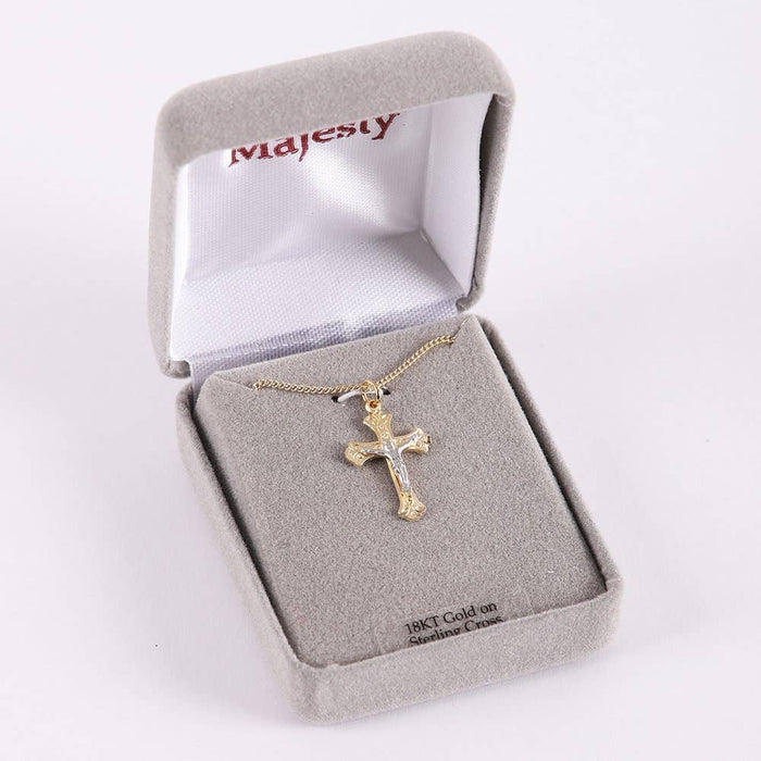 Gold cross necklace in a 'Majesty' branded box on a white background