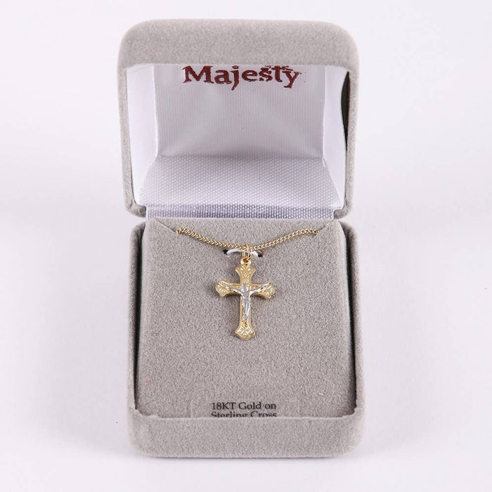 Gold cross necklace in a 'Majesty' branded box on a white background