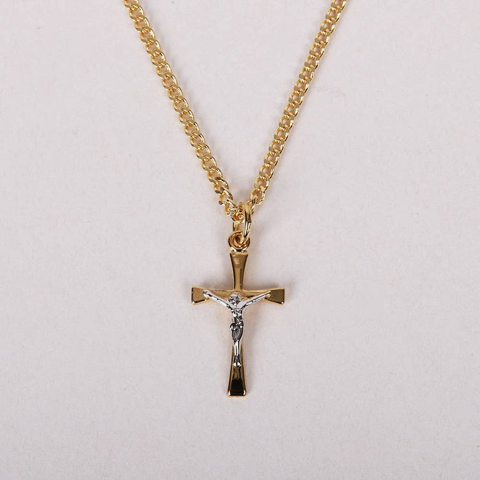 Gold cross necklace with chain on a light gray background