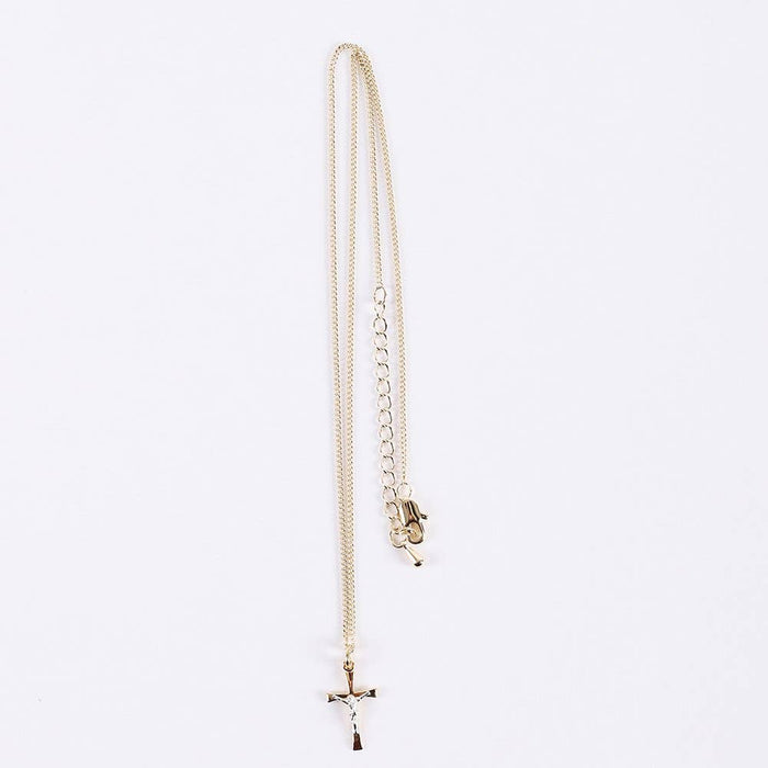 Gold necklace with a small pendant on a light gray background