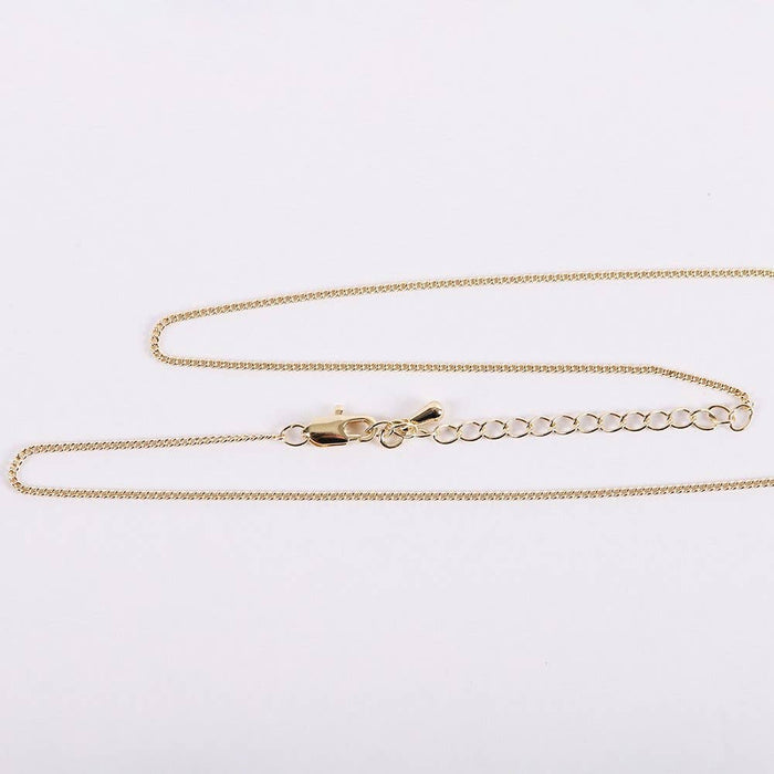 Gold chain necklace on a light gray background