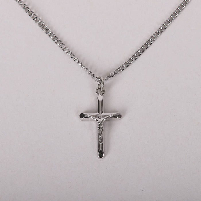 Silver crucifix pendant on a chain against a light gray background