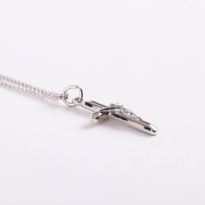 Silver cross necklace on a white background