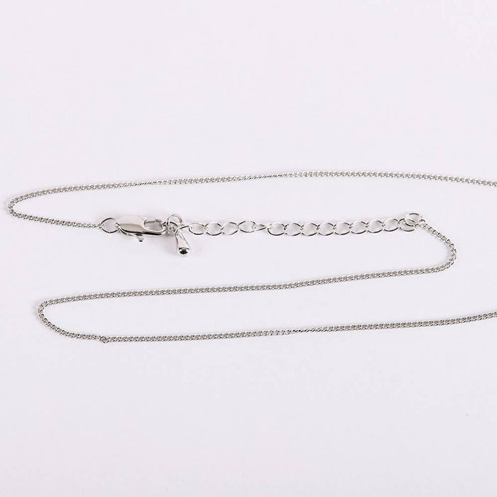 Silver chain necklace on a light gray background
