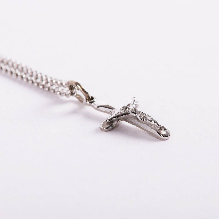 Silver cross necklace on a white background