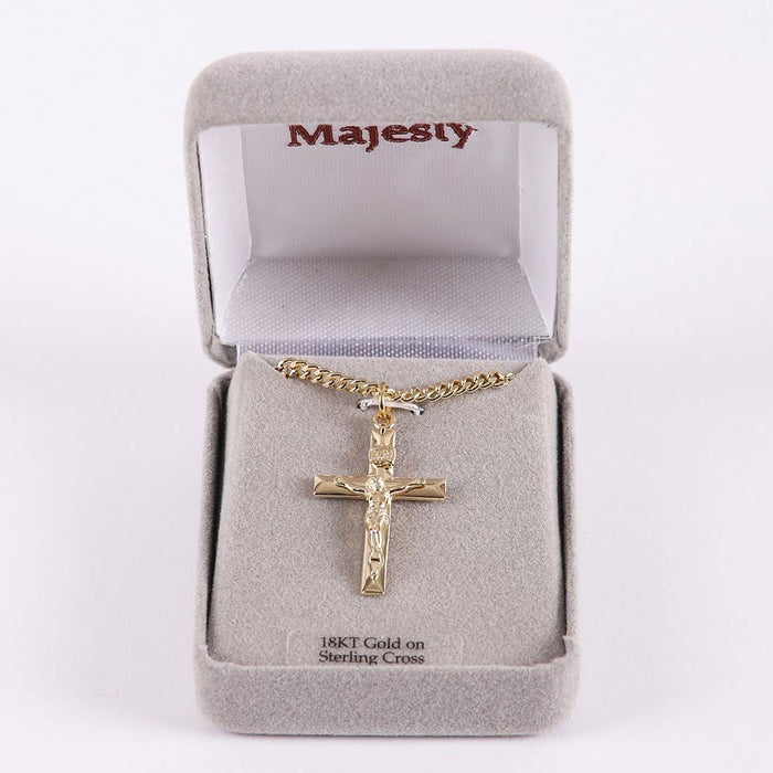 Gold crucifix necklace in a 'Majesty' jewelry box on a white background